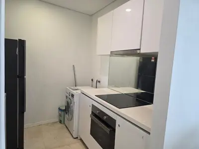 a kitchen with white cabinets and a black appliance at Vortex suites klcc by KAZI in Kuala Lumpur