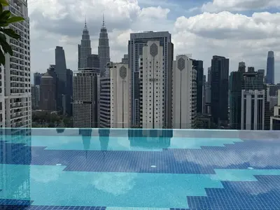 a large swimming pool with a view of a city at The Majestic Residence KLCC By Castle in Kuala Lumpur