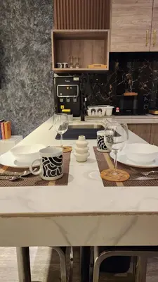 a kitchen with a table with plates and wine glasses at Dsir Lustful KL Jacuzzi NFLX Prjscn120 TV65 in Kuala Lumpur