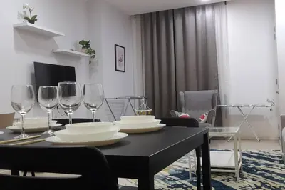 a dining room table with glasses and plates on it at Kuala Lumpur Mont Kiara Arcoris SOHO 5 Pax, Walk to Mall, Pool, WIFI in Kuala Lumpur