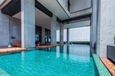 a large swimming pool with blue water in a building at Kuala Lumpur Mont Kiara Arcoris SOHO 5 Pax, Walk to Mall, Pool, WIFI in Kuala Lumpur