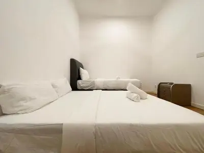 a bedroom with a large bed with white sheets at St Mary Residence by PILLOWTALKS in Kuala Lumpur