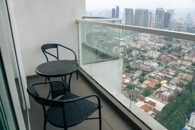 two chairs and a table on a balcony with a view at KL Luxury Residence 3BR Golden Triangle in Kuala Lumpur
