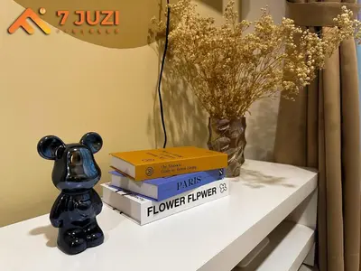 a pile of books sitting on a table with a vase at KLCC 23A Premium 1B1R with Best View Infinity Pool and Netflix 1080HD in Kuala Lumpur