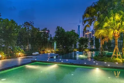 a swimming pool with palm trees and a building at Agile Bukit Bintang TRX KL City by Cobnb in Kuala Lumpur