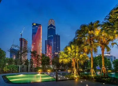 a city skyline at night with a pool and palm trees at Agile Bukit Bintang TRX KL City by Cobnb in Kuala Lumpur