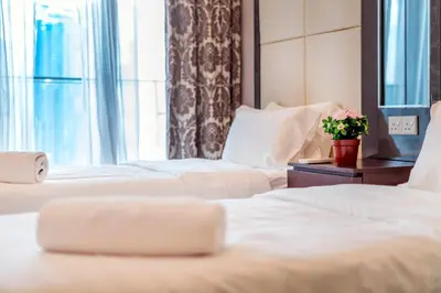 a hotel room with three beds and a window at Dorsett Bukit Bintang near Pavilion KL, Kuala Lumpur in Kuala Lumpur