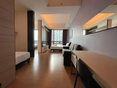 a living room with a couch and a bed in a room at Swiss Garden Residence by PILLOWTALKS in Kuala Lumpur