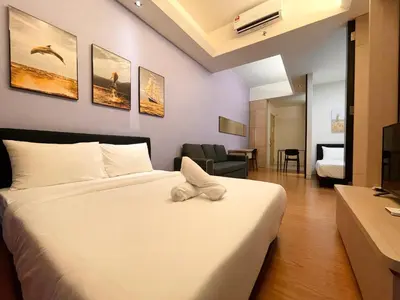 a hotel room with a bed with a towel on it at Swiss Garden Residence by PILLOWTALKS in Kuala Lumpur