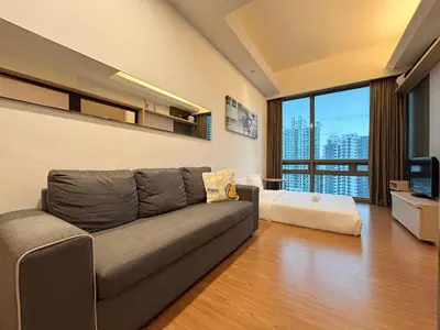 a living room with a couch and a bed at Swiss Garden Residence by PILLOWTALKS in Kuala Lumpur