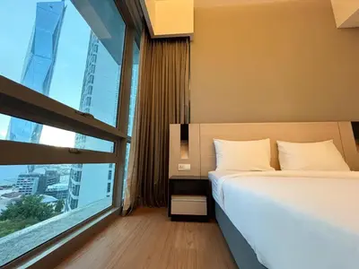 a bedroom with a bed and a large window at Swiss Garden Residence by PILLOWTALKS in Kuala Lumpur