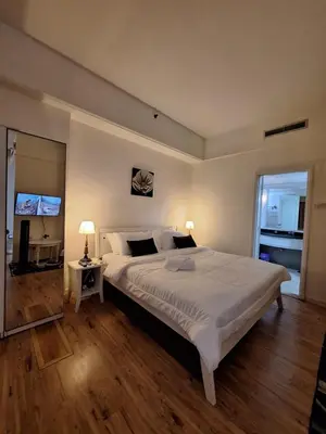 a bedroom with a large white bed and a television at Times Square Service Apartment , Kuala Lumpur in Kuala Lumpur