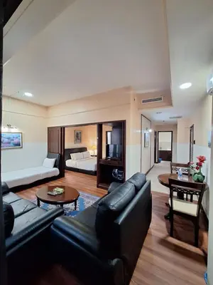 a living room with a black leather couch and a room at Midtown Suite At Times Square Hotel KL in Kuala Lumpur