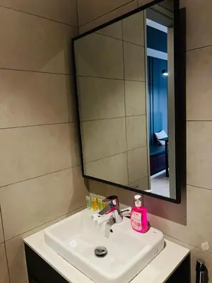 a bathroom sink with a mirror and a pink soap dispenser at Axon suites bukit bintang Klcc by Aura in Kuala Lumpur