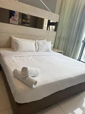 a bed with a rolled up towel on it at PARKVIEW RESIDENCE KLCC By IKNAS SUITES in Kuala Lumpur