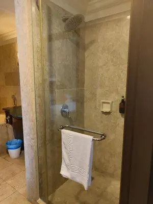 a bathroom with a shower with a white towel at Visitor Suites At Times Square Kuala Lumpur in Kuala Lumpur