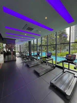 a row of treadmills in a gym with a pool at Star Residences One klcc in Kuala Lumpur