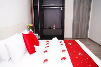 a bedroom with a white bed with red pillows at Agile Kuala Lumpur City Centre By AMG in Kuala Lumpur