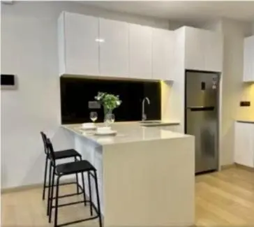 a kitchen with a counter with two chairs and a refrigerator at Star Residences One KLCC in Kuala Lumpur