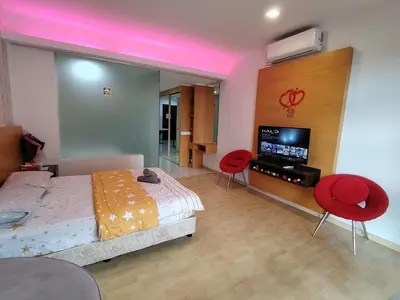 a bedroom with a bed and two red chairs at KL studio with Private Jacuzzi in Kuala Lumpur