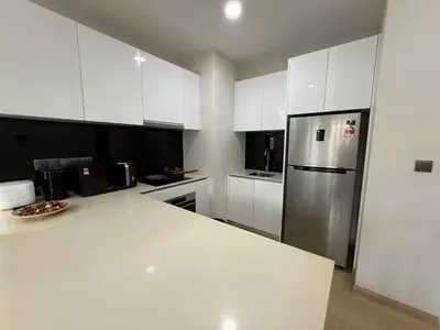 a kitchen with white cabinets and a stainless steel refrigerator at STAR Suites Residence KLCC in Kuala Lumpur