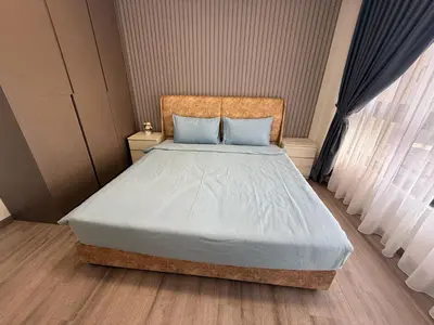 a bedroom with a large bed with blue pillows at Majestic Residence KLCC Sky view in Kuala Lumpur
