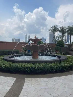 a fountain in a park with people standing around it at City view Apartment at Times square in Kuala Lumpur
