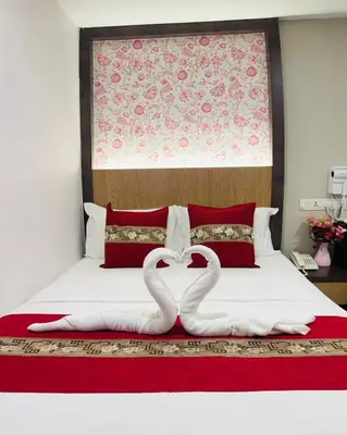 two white swans making a heart on a bed at Elite Hotel KL Sentral in Kuala Lumpur