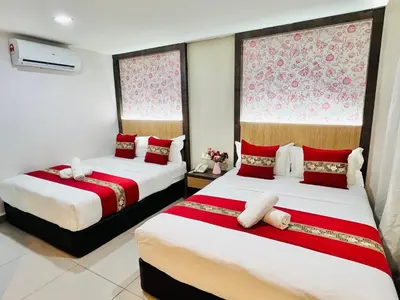 two beds in a room with red and white at Elite Hotel KL Sentral in Kuala Lumpur