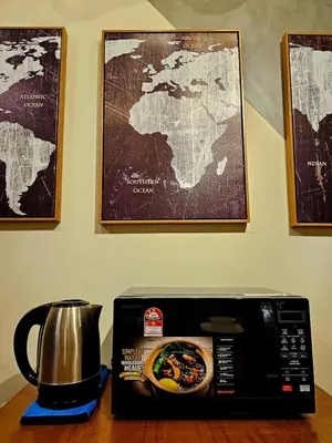 a microwave sitting on top of a table with a coffee pot at Metro Studio - Direct LRT access, near Pantai Hospital, University Malaya, Mid Valley, Bangsar in Kuala Lumpur