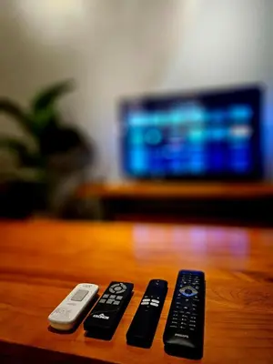 two remote controls sitting on top of a wooden table at Metro Studio - Direct LRT access, near Pantai Hospital, University Malaya, Mid Valley, Bangsar in Kuala Lumpur