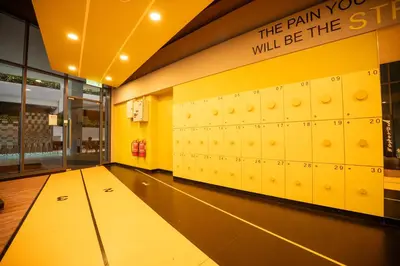 a room with lockers in a gym with the pain you will be the sign at 2PAX-4PAX Projector Screen Stay near KLCC & Jelatek LRT Station in Kuala Lumpur