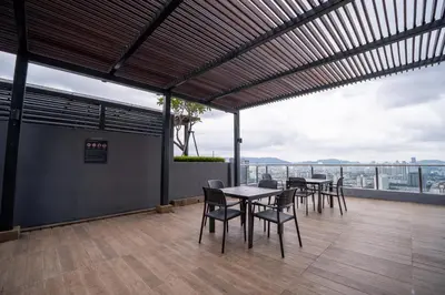 a patio with tables and chairs on a roof at 2PAX-4PAX Projector Screen Stay near KLCC & Jelatek LRT Station in Kuala Lumpur