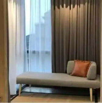 a couch with a pillow sitting in front of a window at Star Residences One klcc in Kuala Lumpur
