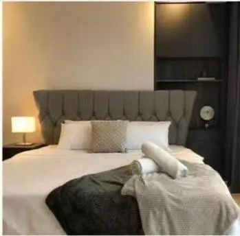 a bedroom with a large bed with a large headboard at Star Residences One klcc in Kuala Lumpur