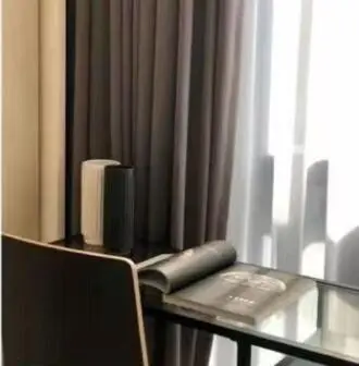 a glass table with a phone on a table with a book at Star Residences One klcc in Kuala Lumpur