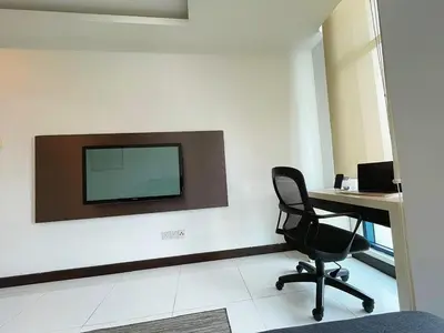 an office with a desk and a chair and a television on a wall at Casa Residency Apartment Bukit Bintang by Cupid home in Kuala Lumpur