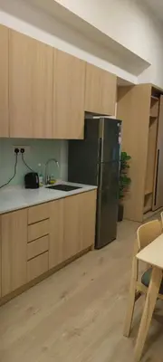a kitchen with wooden cabinets and a stainless steel refrigerator at Sky Touch Homestay in Kuala Lumpur