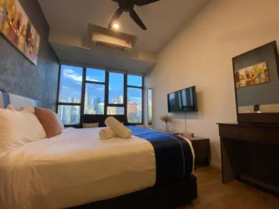 a bedroom with a large bed with a large window at Ceylonz suites Klcc by StayLa in Kuala Lumpur
