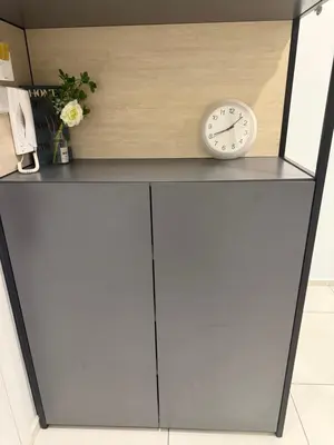 a clock sitting on top of a white cabinet at Robertson Residence in Kuala Lumpur in Kuala Lumpur