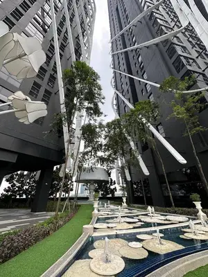 a courtyard with tables and chairs in front of tall buildings at Cosy Place in Kuala Lumpur
