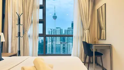 a bedroom with a bed and a desk and a window at Balcony Cityscape V The Robertson Residence 36f in Kuala Lumpur