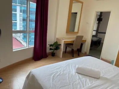 a bedroom with a bed and a desk and a window at Kuala Lumpur city centre in Kuala Lumpur