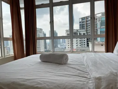 a bed with a pillow on it in front of a window at Kuala Lumpur city centre in Kuala Lumpur