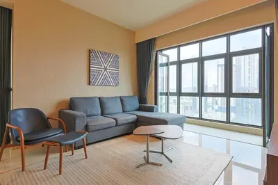 a living room with a couch and a table and chairs at 8 min walk to Pavilion KL - Infinity Pool w TRX view in Kuala Lumpur