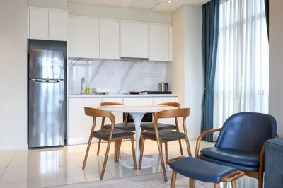 a kitchen with a table and chairs in a room at 8 min walk to Pavilion KL - Infinity Pool w TRX view in Kuala Lumpur
