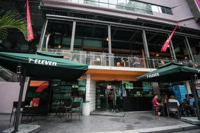 a restaurant with two green umbrellas in front of a building at Soho Suites @ KLCC by Luxury Suites Asia in Kuala Lumpur