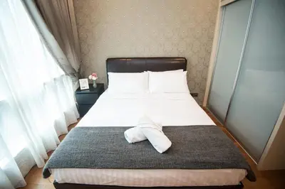 a bed with a white pillow sitting on top of it at Soho Suites @ KLCC by Luxury Suites Asia in Kuala Lumpur