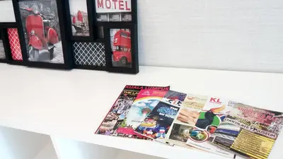 a shelf with magazines and pictures on a wall at Soho Suites @ KLCC by Luxury Suites Asia in Kuala Lumpur