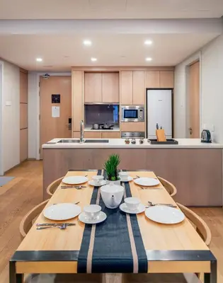 a kitchen with a wooden table with plates on it at 188 Suites near KLCC with Parking and Bathtub in Kuala Lumpur